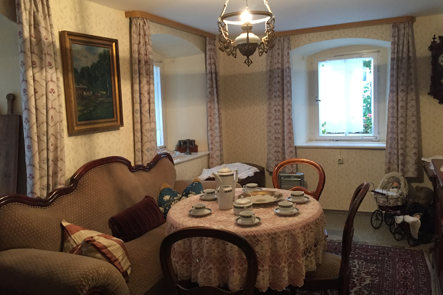 Nostalgischer Wohnraum mit Sofa und gedecktem Kaffeetisch Nostalgischer Wohnraum mit Sofa und gedecktem Kaffeetisch